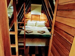 a small room with a bed in a staircase at Chalé Família Rigolo 1 Anthony in Monte Verde