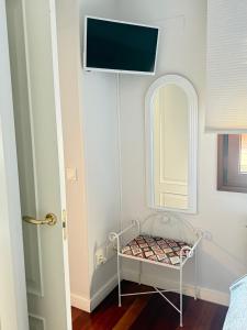 a room with a mirror and a tv on the wall at MIRADOR DEL CIELO "Parking incluido" in Ávila
