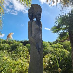 a statue of a woman standing in the grass at Vilamar - Ribamar in Ribamar