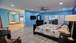 a bedroom with blue walls and a bed and a bathroom at 100Ft To Beach,Beachview,EV charger,Heated Pool,Jacuzzi in South Padre Island +66 photos