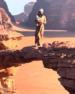 a woman standing on a rock in the desert at Rum moon in Wadi Rum +4 photos