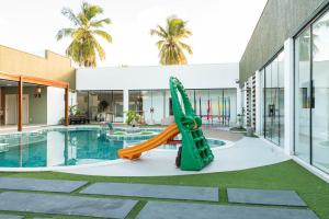 a slide in front of a building with a pool at Mansão pontal beach in Pontal