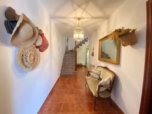a hallway with a chair and a hat on the wall at Villa Buganvilla in Arnuero