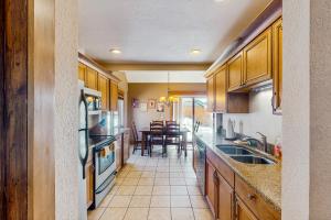 a kitchen with wooden cabinets and a dining room at Mountain Dreams Condo in Fraser