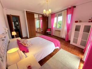 a bedroom with a large bed with pink curtains at Villa Buganvilla in Arnuero +18 photos