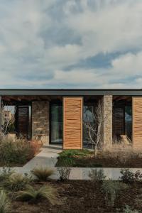 スカラ・エレソスにあるBarefoot Luxury Eressos Apartmentsのレンガ造りの家(木製のドア、窓付)