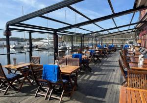 a row of tables and chairs on a deck at Guest House Gäststuga Bullandö in the archipelago in Värmdö