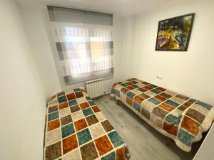 two beds in a small room with a window at Apartamento Ponent Stays in Almacellas