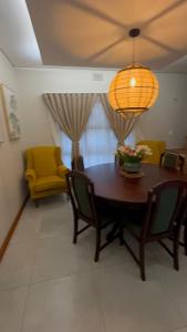 a dining room with a table and chairs and a lamp at Fossa Dei Leoni Full Guest House in Roodepoort