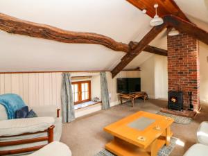 a living room with a couch and a fireplace at Slade Cottage in Ashbourne