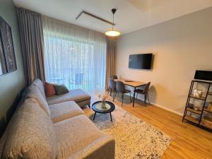 a living room with a couch and a table at Katrina - Kunigiškių apartamentai - Mano Jūra 2 in Palanga