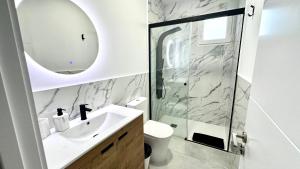 a bathroom with a sink and a shower with a mirror at The white house in Vecindario