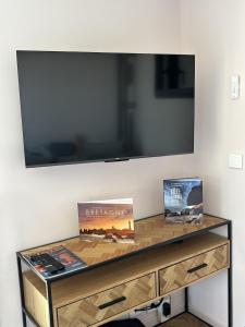 a table with a television on a wall with books at Ty Ana Gwen in Trébeurden