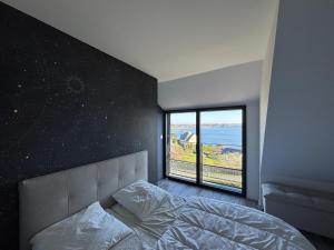 a bedroom with a bed and a large window at Ty Ana Gwen in Trébeurden