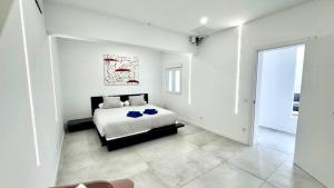 a white bedroom with a bed and a large window at The white house in Vecindario