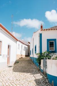 a cobblestone street in a town with white buildings at Modern Old Town House with Sunny Terrace in Vila do Bispo +17 photos
