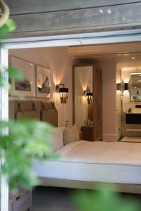 a bedroom with a large bed and a room with a sink at âmé by NOAH in Cape Town