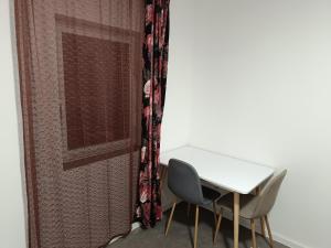 Ein Tisch und zwei Stühle neben einem Vorhang in der Unterkunft Özbay in Rüsselsheim