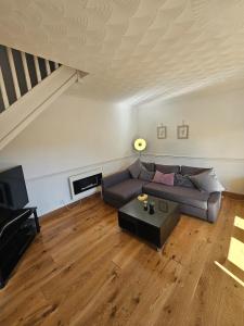 a living room with a couch and a table at Spacious Bournemouth Home with BBQ, Outdoor Seating & large TV in Bournemouth