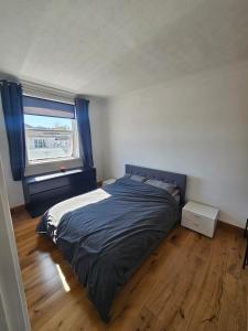 a bedroom with a bed and a window at Spacious Bournemouth Home with BBQ, Outdoor Seating & large TV in Bournemouth