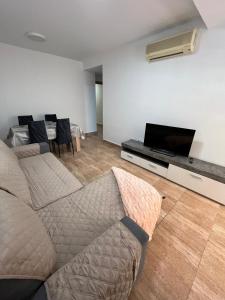 Una sala de estar con un sofá y un televisor de pantalla plana. en APARTAMENTOSOLyMAR, en Oropesa del Mar