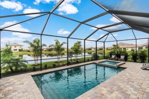 a swimming pool in a glass house with a view at Magnificent 4BR waterfront pool home in Lorraine Lakes- Waterfront Dreamin in Bradenton