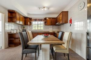 a kitchen with a wooden table and chairs at Por Do Sol in Calheta