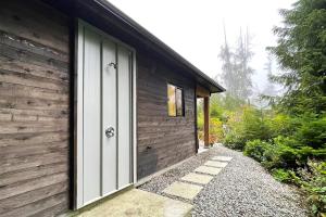a wooden house with a door on the side at Tidal Retreat Cabin in Tofino