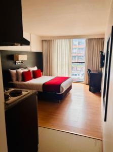 a hotel room with a bed with red pillows at Hotel Silver Javeriana By Hospedium Bogota in Bogotá