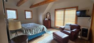 a bedroom with a bed and a chair at Wandering Woods- 3 Bedroom Home with Hot Tub and Firepit in Oakland