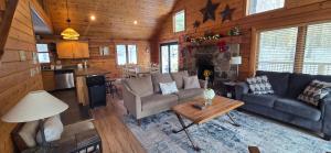 a living room with a couch and a table at Wandering Woods- 3 Bedroom Home with Hot Tub and Firepit in Oakland