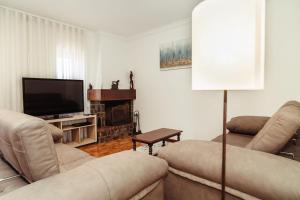 a living room with two couches and a flat screen tv at Moledo's Sea House in Moledo