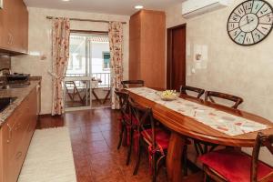 a dining room with a table and a clock on the wall at Moledo's Sea House in Moledo