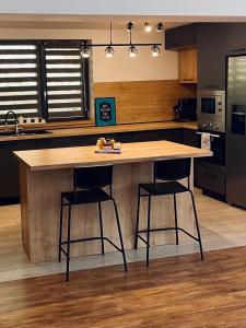 eine Küche mit einem großen Holztisch und zwei Barhockern in der Unterkunft Riverside Avrig in Avrig