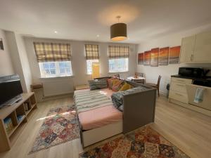a living room with a couch and a kitchen at The London Get Away P & M in West Wickham