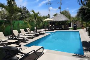 a pool with chaise lounge chairs and a resort at Departamento Mauricio #2 in Bucerías