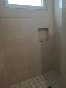 a shower with a glass door with a window at Departamento Mauricio #2 in Bucerías