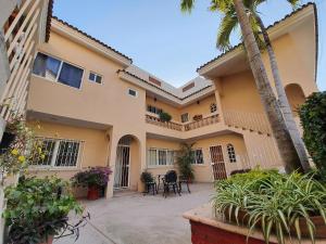 a house with a palm tree in front of it at Departamento Mauricio #2 in Bucerías +2 photos