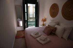 a bedroom with a bed with towels on it at Downtown Lovely in Vila Real