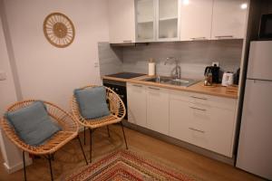 a kitchen with two chairs and a sink at Downtown Lovely in Vila Real