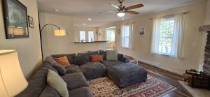 a living room with a couch and a ceiling fan at The Hideaway House- 3 bedroom with Hot Tub, Fenced Yard, Lake Access in Swanton