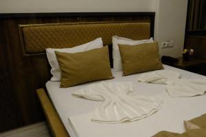 a bed with white sheets and pillows on it at Grand Diamond Hotel in Mersin