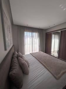 ein Schlafzimmer mit einem großen Bett mit Kissen und einem Spiegel in der Unterkunft Anfa Casablanca in Casablanca
