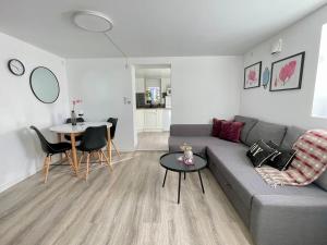 a living room with a gray couch and a table at Charming Modern Apartment Close to Moa & Ålesund in Ålesund