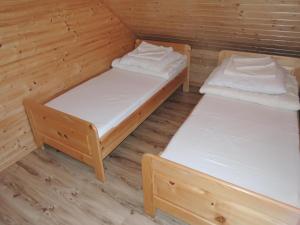 due letti in una cabina con pavimenti in legno di Bungalow in Dziwnów near Baltic Sea a Dziwnów Altre 16 foto