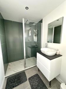 un bagno bianco con lavandino e doccia di Appartement ultra lumineux à Berck-Plage pour 6 personnes a Berck-sur-Mer