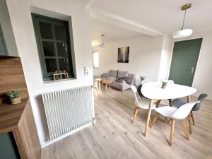 un soggiorno con tavolo, sedie e divano di Appartement ultra lumineux à Berck-Plage pour 6 personnes a Berck-sur-Mer Altre 8 foto