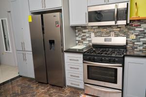a kitchen with a stove and a refrigerator at Bondi's Getaway in Portmore