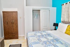 a bedroom with a bed and a wooden cabinet at Bondi's Getaway in Portmore