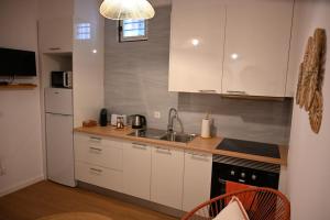 a kitchen with white cabinets and a sink at Downtown Cosy in Vila Real